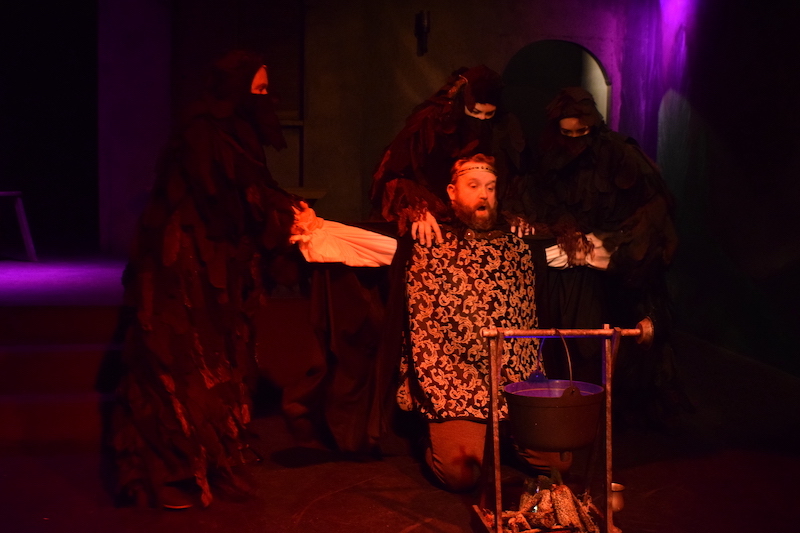 The weird sisters (Yvonne Robertson, Libby Letlow, and Sara Neal) confront Macbeth (Walter Gray IV) with a troubling prediction in Macbeth at the Long Beach Shakespeare Company. (Photo by James Tweet.)